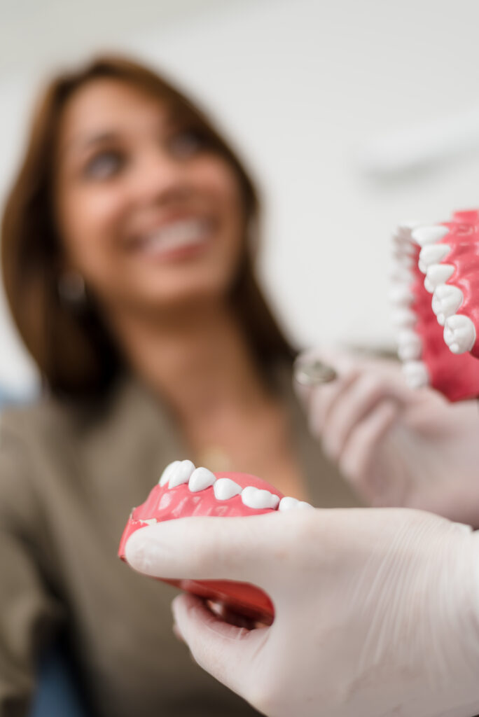 Patient holding dental model while discussing treatment options