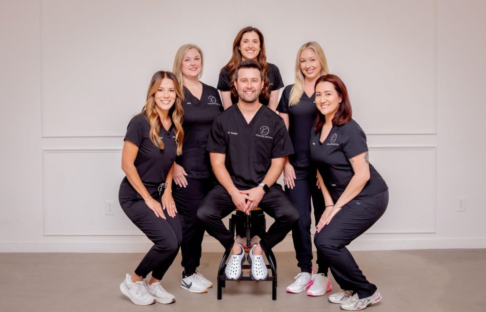 Dr. Kris Koelker and the Koelker Dental team in Allen, TX wearing black scrubs for a group practice photo